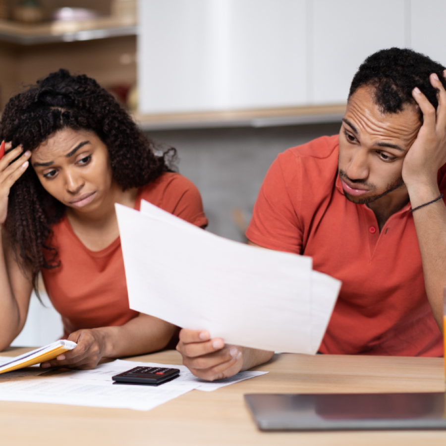 sad-young-black-couple-work-with-documents-pc-suffering-from-crisis-kitchen-interior